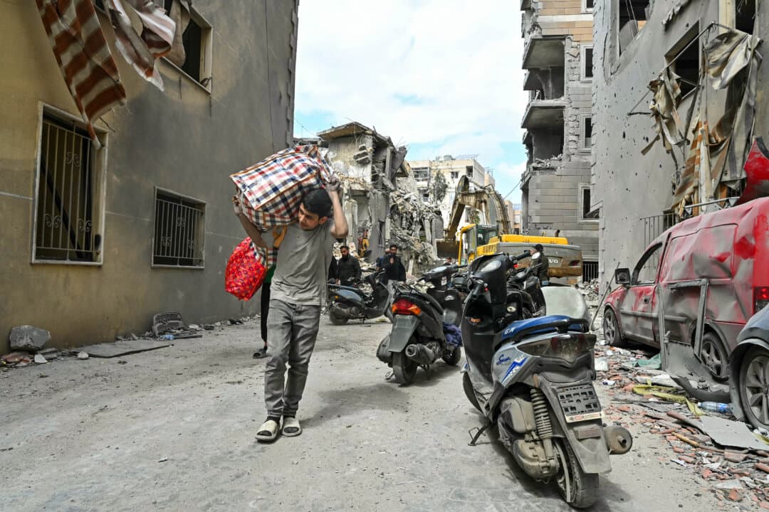 Residents carry salvaged belongings in Chweifat-Amrousiyeh, southern Beirut, Lebanon, after an Israeli strike earlier in the week, on April 10, 2026. The Israeli military said it has dismantled more than 4,300 Hezbollah sites in Lebanon since fighting began last month. (Fadel Itani/AFP via Getty Images)