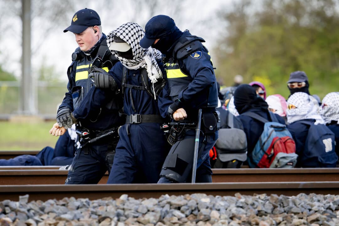 Police officers remove activists from a railway line during a protest against human rights violations and the climate crisis near Elst, Netherlands, on April 10, 2026. (Sem van der Wal/ANP/AFP via Getty Images)
