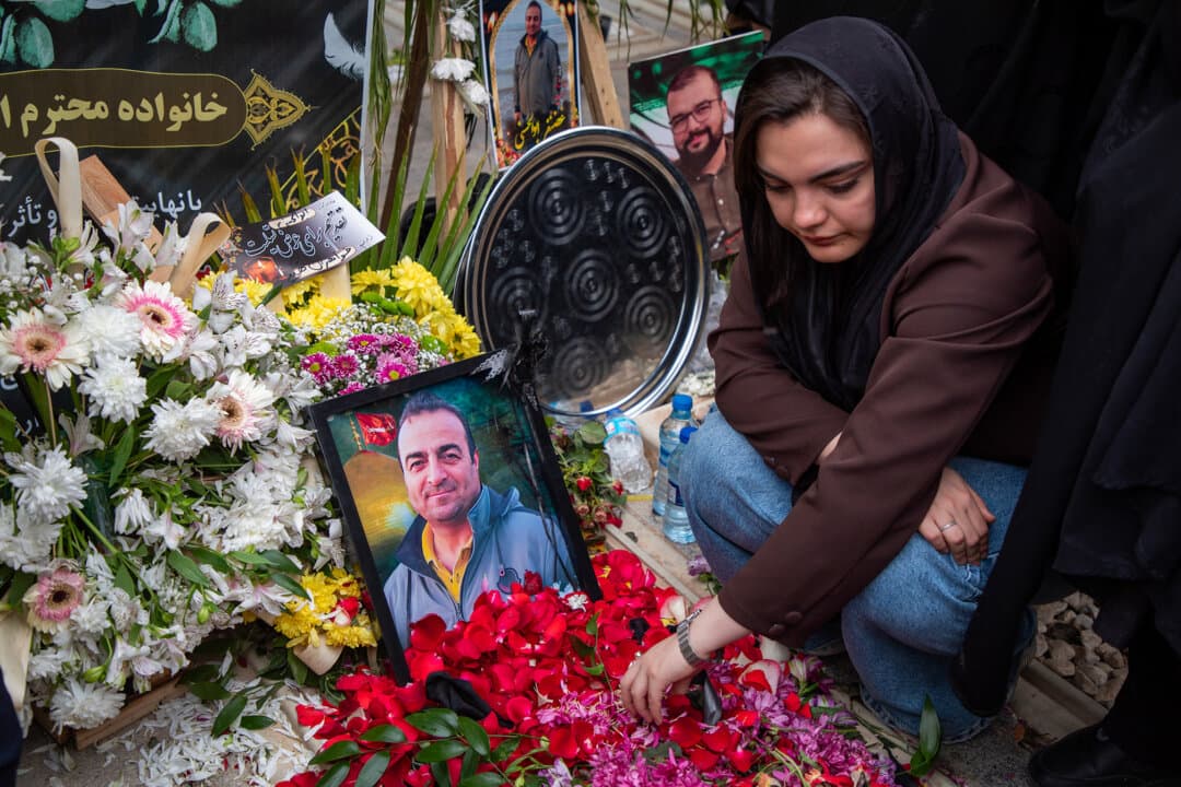 A woman sits by a grave as people gather to mourn on the 40th day since a number of Iranians were killed in U.S.-Israeli joint strikes, at Behesht-e Zahra Cemetery in Tehran, Iran, on April 16, 2026. (Majid Saeedi/Getty Images)
