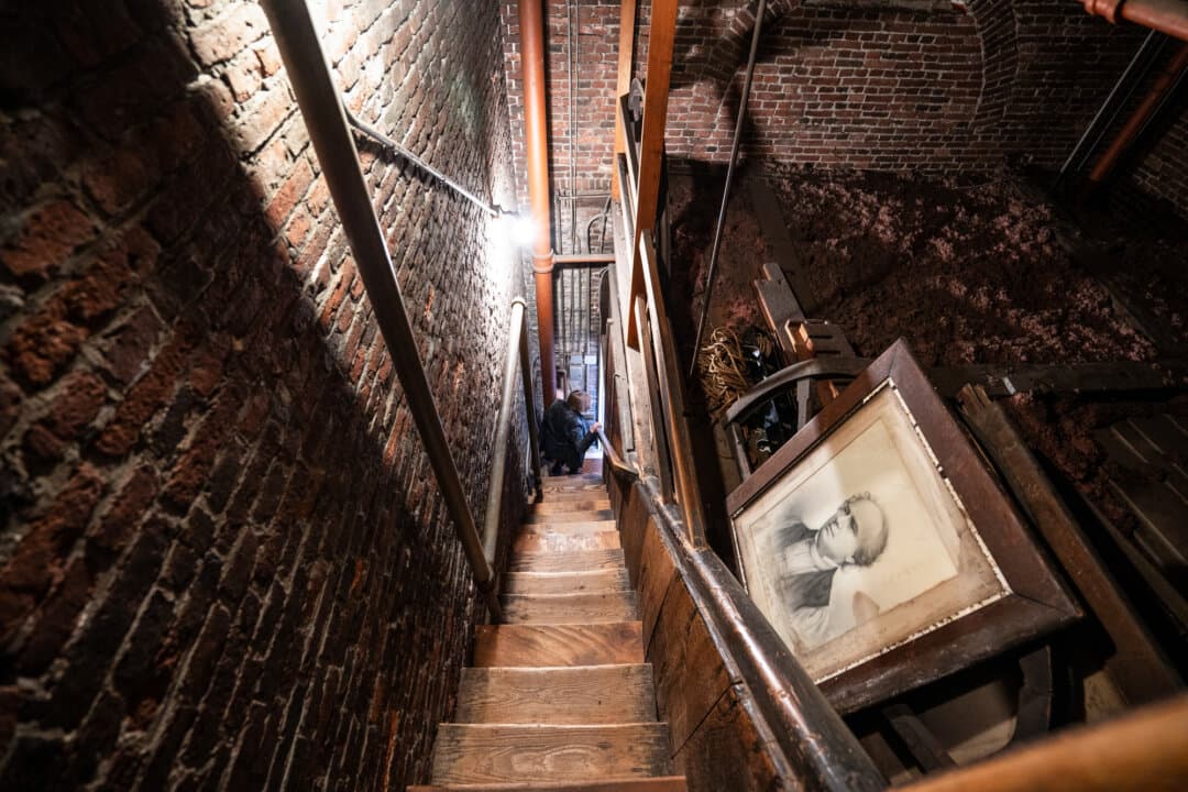 (Top Left) A replica of the 1792 contract that Paul Revere signed to serve as a bell ringer at the Old North Church is displayed in Boston on April 8, 2026. (Top Right) A bust of George Washington is displayed inside the Old North Church in Boston on April 8, 2026. (Bottom Left) Photos on display in Boston on April 8, 2026, show the church’s steeple collapse during Hurricane Carol on Aug. 31, 1954. (Bottom R) The Old North Church in Boston on April 8, 2026. (Samira Bouaou/The Epoch Times)