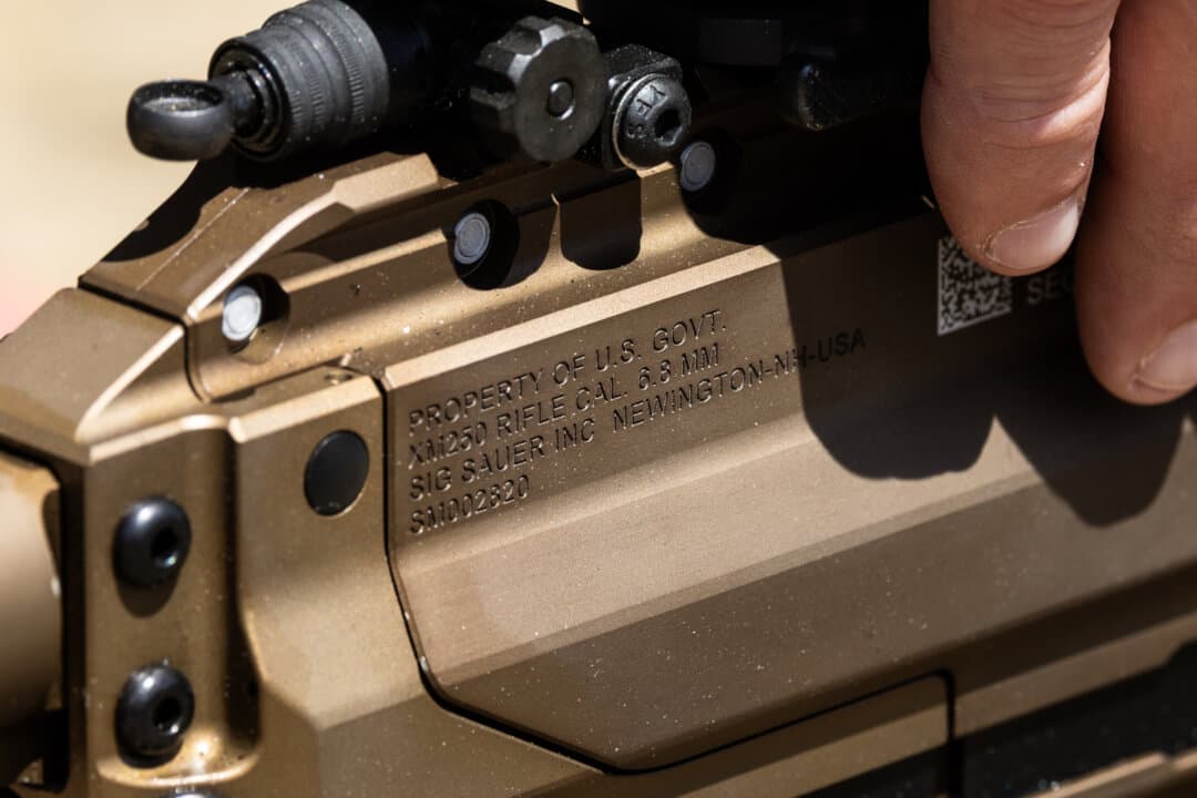 Sig Sauer representatives display the M240 machine gun as soldiers with the United States Army perform shooting exercises with the weapon at Fort Benning, Ga., on April 8, 2026. (John Fredricks/The Epoch Times)