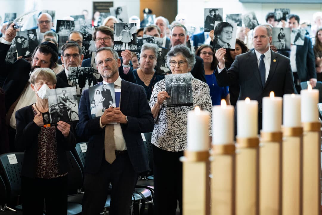 Attendees hold up photographs of people killed during the Holocaust during the U.S. Holocaust Memorial Museum’s National Commemoration of the Days of Remembrance ceremony at the U.S. Capitol on April 14, 2026. Days of Remembrance, held every year since 1979, commemorates the six million Jewish men, women, and children systematically murdered in the Holocaust and the survivors, as well as the millions of other victims of Nazi persecution. (Saul Loeb/AFP via Getty Images)