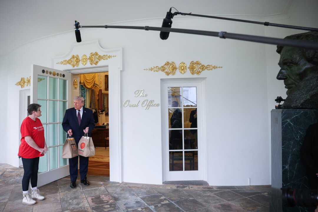 President Donald Trump receives a DoorDash delivery of McDonald’s from Sharon Simmons before he speaks to the press during an event outside the Oval Office on April 13, 2026. (Win McNamee/Getty Images)