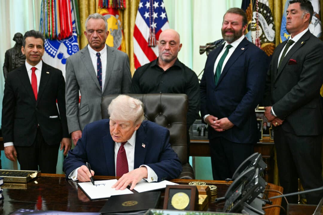 (L-R) FDA Commissioner Marty Makary, Health and Human Services Secretary Robert F. Kennedy Jr., U.S. media personality Joe Rogan, CEO of Americans for Ibogaine W. Bryan Hubbard, and former Navy SEAL Marcus Luttrell look on as President Donald Trump signs an executive order in the Oval Office on April 18, 2026. The executive order aims to further U.S. federal medical research and clinical trials for certain psychedelic drugs. (Jim Watson/AFP via Getty Images)