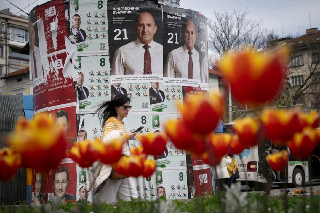 A woman passes election posters of the Progressive Bulgaria coalition's leader and former President Rumen Radev in Sofia, Bulgaria, on April 20, 2026. Bulgaria held its eighth legislative election in five years, with ex-president Rumen Radev's grouping expected to win on a pledge to fight corruption, after an anti-graft movement triggered a long political crisis. (Nikolay Doychinov/AFP via Getty Images)