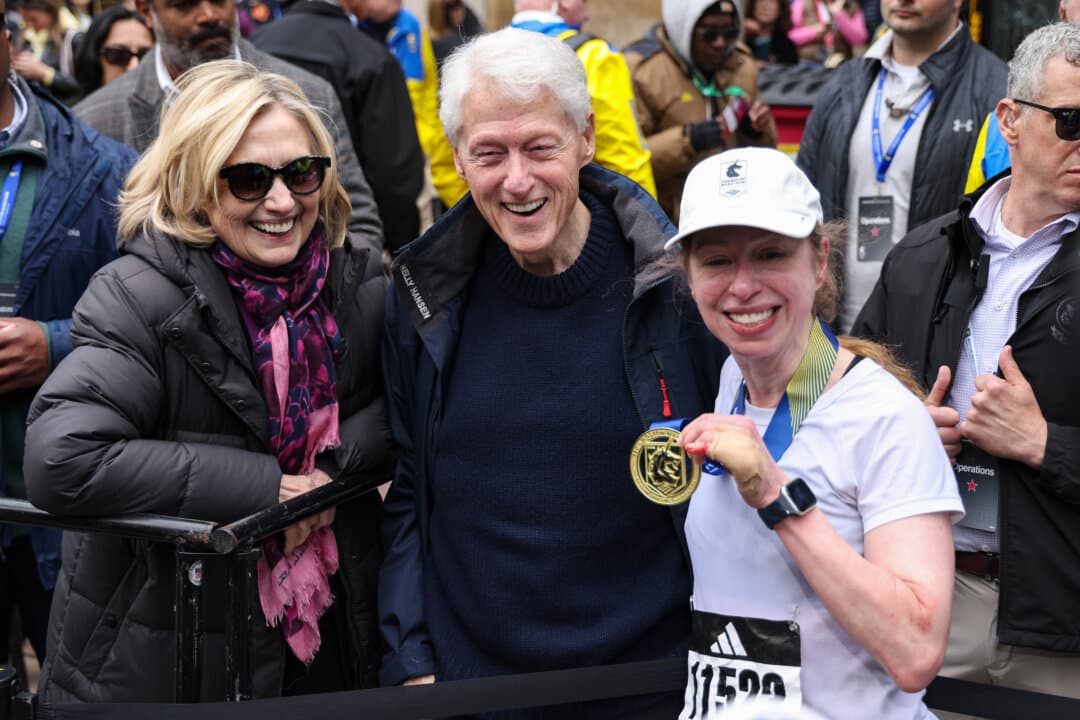 Former President Bill Clinton, former Secretary of State Hillary Clinton, and Chelsea Clinton pose after Chelsea Clinton finished the 130th Boston Marathon on April 20, 2026. (Paul Rutherford/Getty Images)