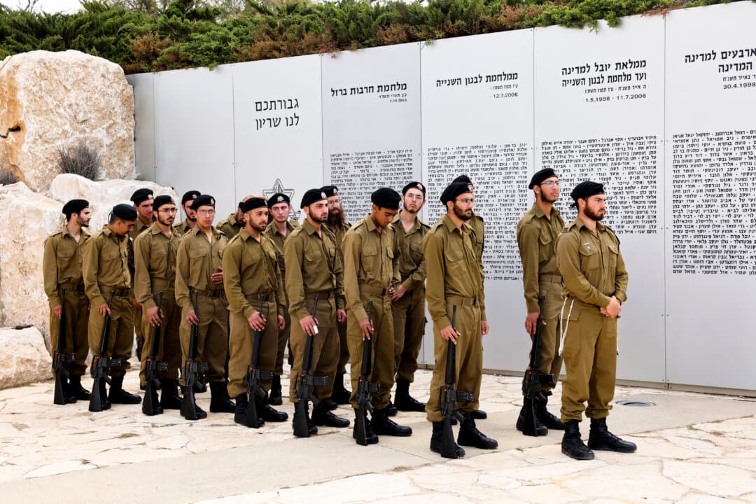 Israeli soldiers observe a two-minute silence at the Armored Corps Memorial, following a Remembrance Day ceremony for fallen Israeli soldiers in Latrun, between Jerusalem and Tel Aviv on April 21, 2026. At sunset on April 20, gatherings at military cemeteries and war memorials gave way to public performances, street parties and general merrymaking to mark 78 years since the declaration of the Israeli state in 1948. (Jack Guez/AFP via Getty Images)