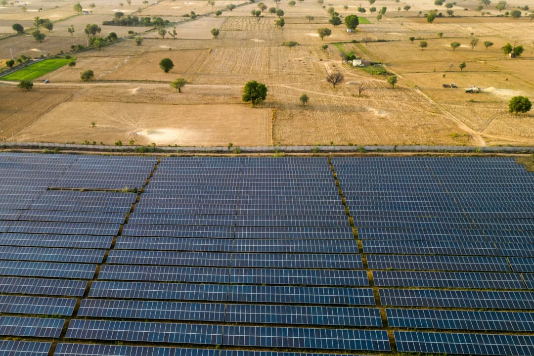 Solar panels are arranged in rows across a power plant in Haryana, India, on April 22, 2026. India, which imports roughly 88 percent of its crude oil and had been steadily expanding purchases of discounted Iranian barrels before the U.S.–Iran conflict escalated, now faces mounting pressure to secure alternative supplies as tanker insurance costs and shipping routes through the Persian Gulf come under renewed strain. (Ritesh Shukla/Getty Images)