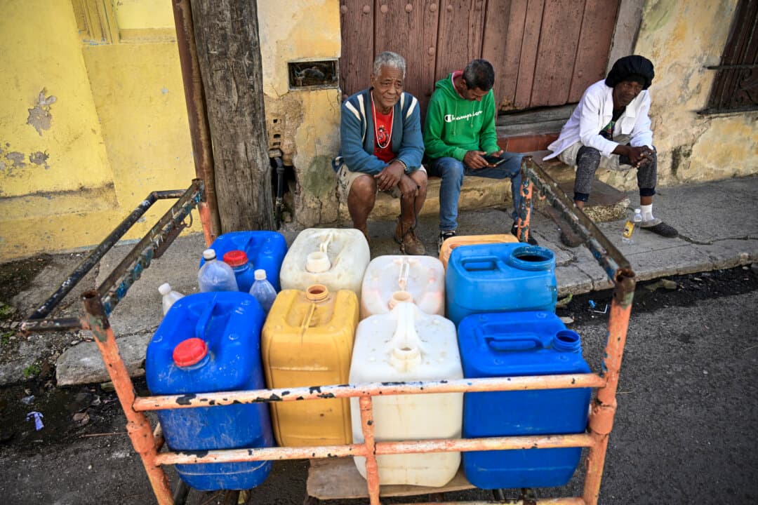 People wait to fill their water containers during a nationwide blackout in Havana on March 22, 2026. Cuban authorities scrambled on March 22 to restore power to the island after the second nationwide blackout in less than a week, as the grid struggles due to an aging infrastructure and a U.S. oil blockade. (Yamil Lage/AFP via Getty Images)