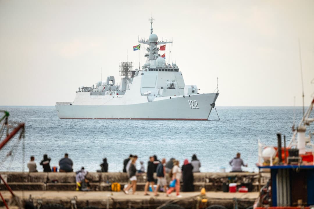 People walk in Kalk Bay harbor as the Chinese guided-missile destroyer Tangshan is moored in False Bay, near Cape Town, South Africa, on Jan. 6, 2026. China's commercial dominance of the sea could spill over into the military side, analysts say. (Rodger Bosch/AFP via Getty Images)