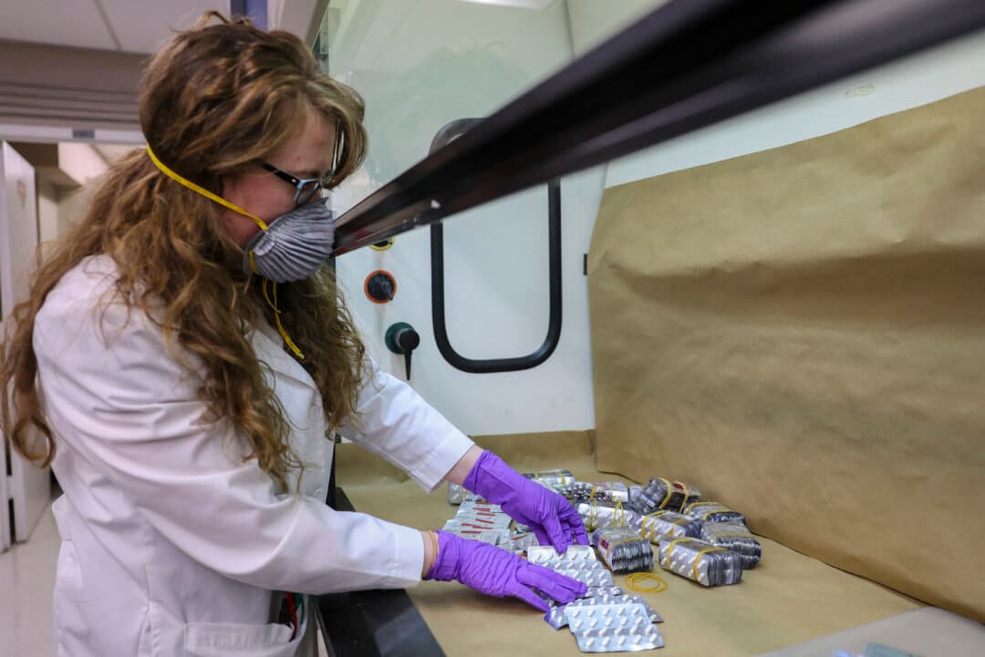 A Drug Enforcement Administration (DEA) chemist sorts through pill blister packages believed to contain fentanyl at the DEA's Northeast Regional Laboratory for testing, in New York City on May 7, 2026. (Angela Weiss/AFP via Getty Images)