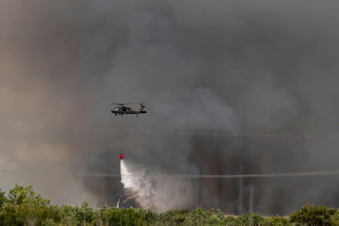 A Florida National Guard helicopter dumps water on the Max Road Miramar fire in Pembroke Pines, Fla., on May 11, 2026. (Joe Raedle/Getty Images)