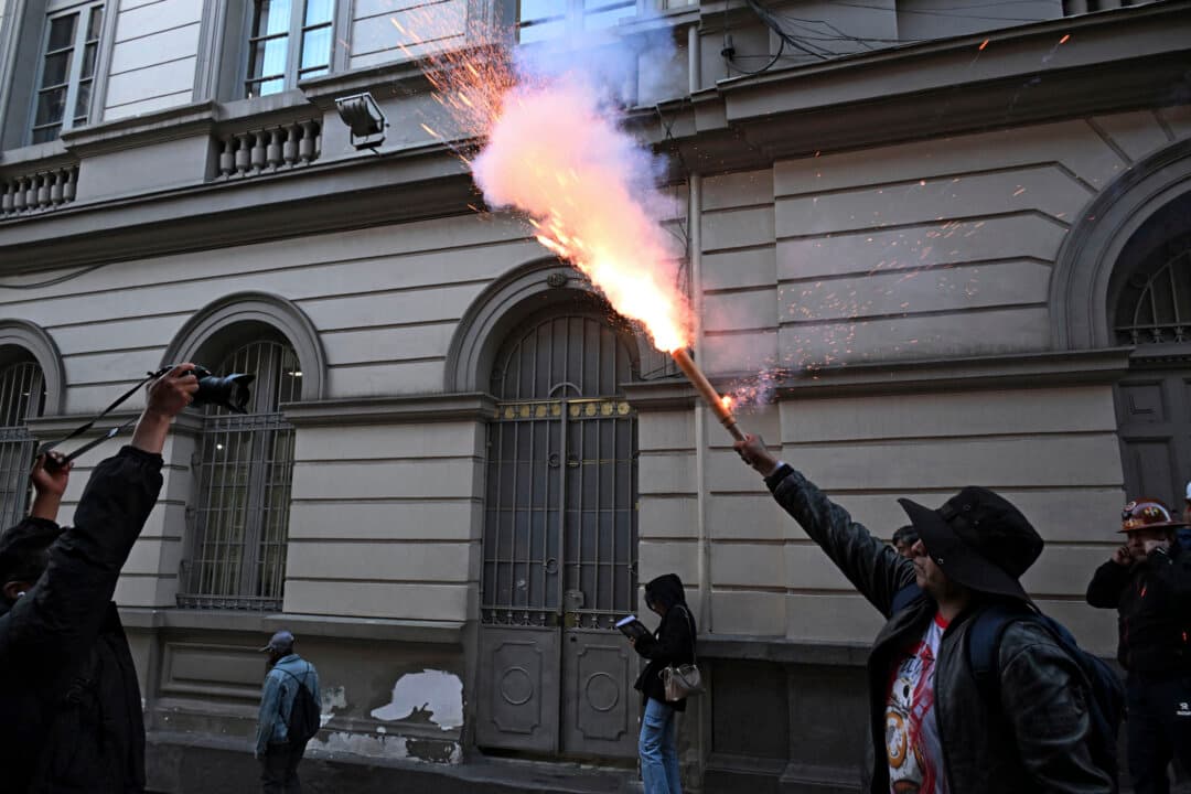A worker shoots fireworks during a protest march demanding the government of Rodrigo Paz to grant a salary increase in downtown La Paz, Bolivia, on May 11, 2026. (Aizar Raldes/AFP via Getty Images)