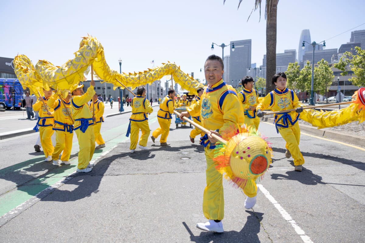 Yu Yang, a Bay Area customized tour guide, leads the dragon dance in the Falun Dafa parade in San Francisco on May 9, 2026. (Lear Zhou/The Epoch Times)