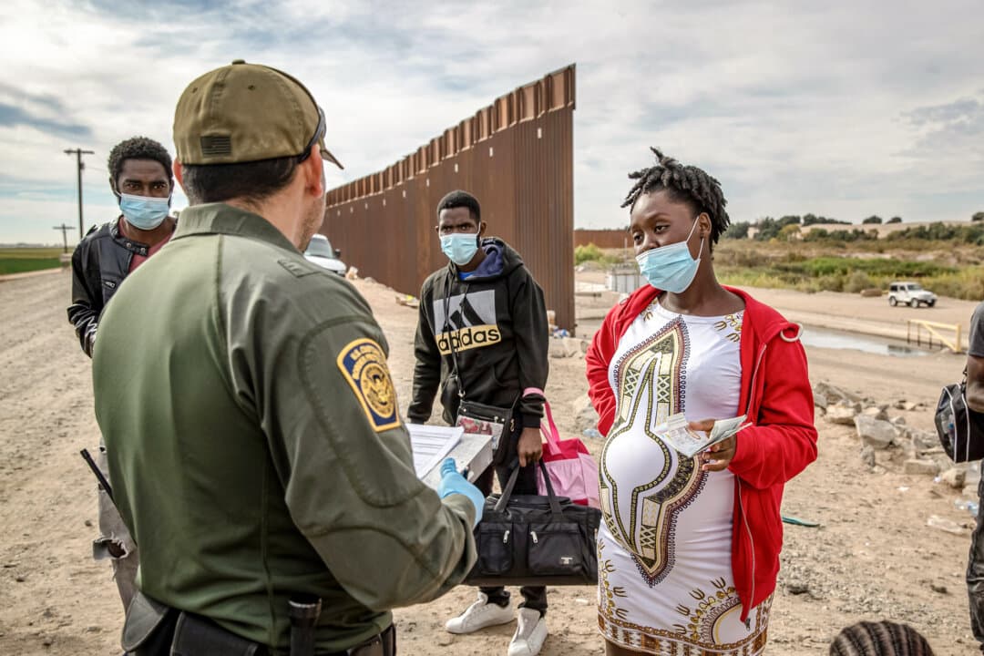 Migrants, including a pregnant Haitian woman seeking to give birth in the United States, are apprehended by a U.S. Border Patrol agent in Yuma, Ariz., on Dec. 7, 2021. The Supreme Court is expected to rule on the constitutionality of an executive order from President Donald Trump aimed at restricting birthright citizenship before the end of June. (John Moore/Getty Images)