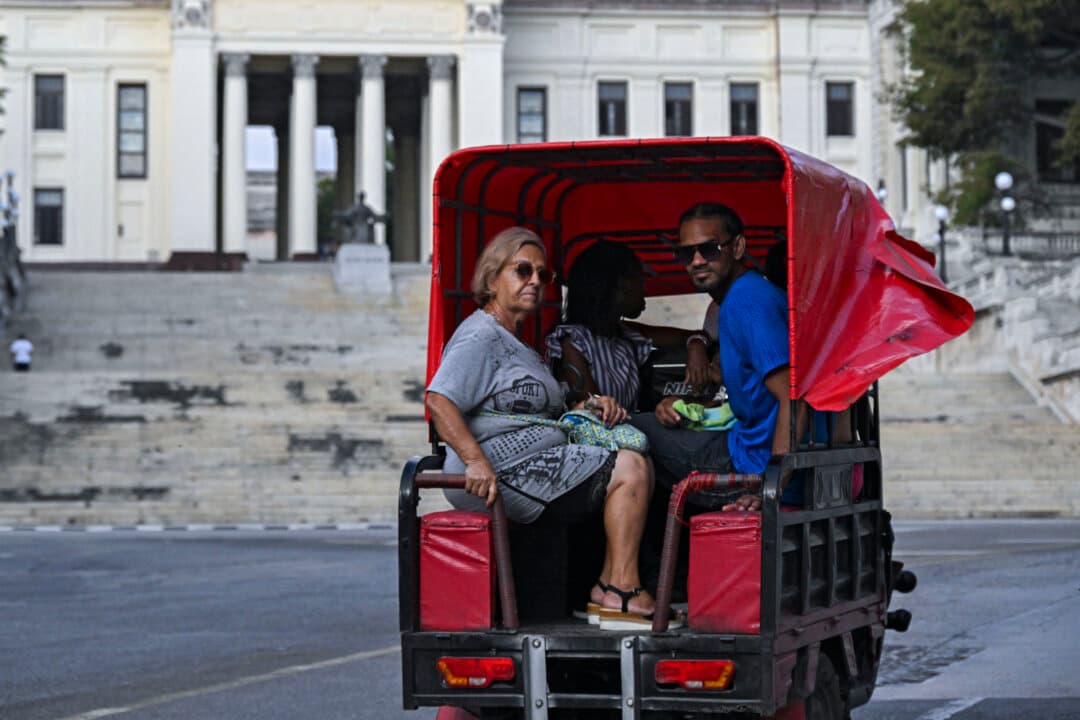People ride an electric tricycle along a street in Havana on May 13, 2026, after the Cuban government announced it would replace the fixed retail price of fuel with a variable price based on import costs. (Yamil Lage/AFP via Getty Images)