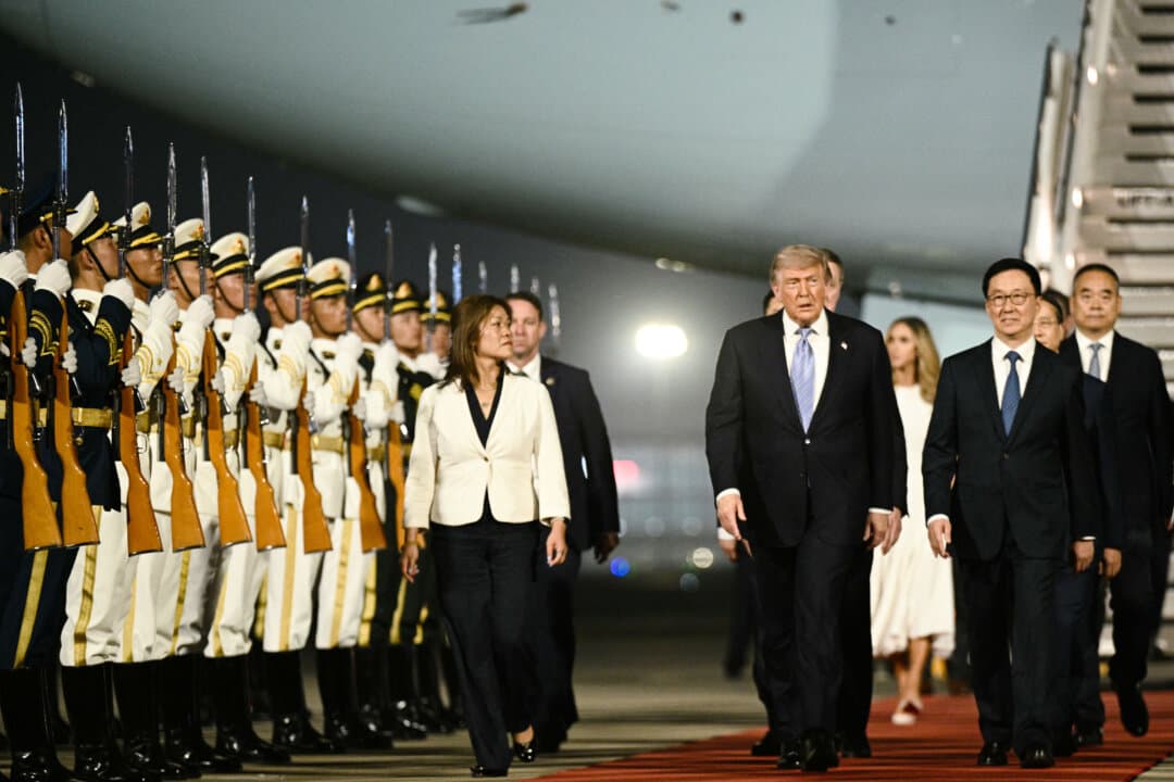 U.S. President Donald Trump (C) is escorted by China’s Vice President Han Zheng (R) upon his arrival at Beijing Capital Airport in Beijing on May 13, 2026. (Brendan Smialowski/AFP via Getty Images)