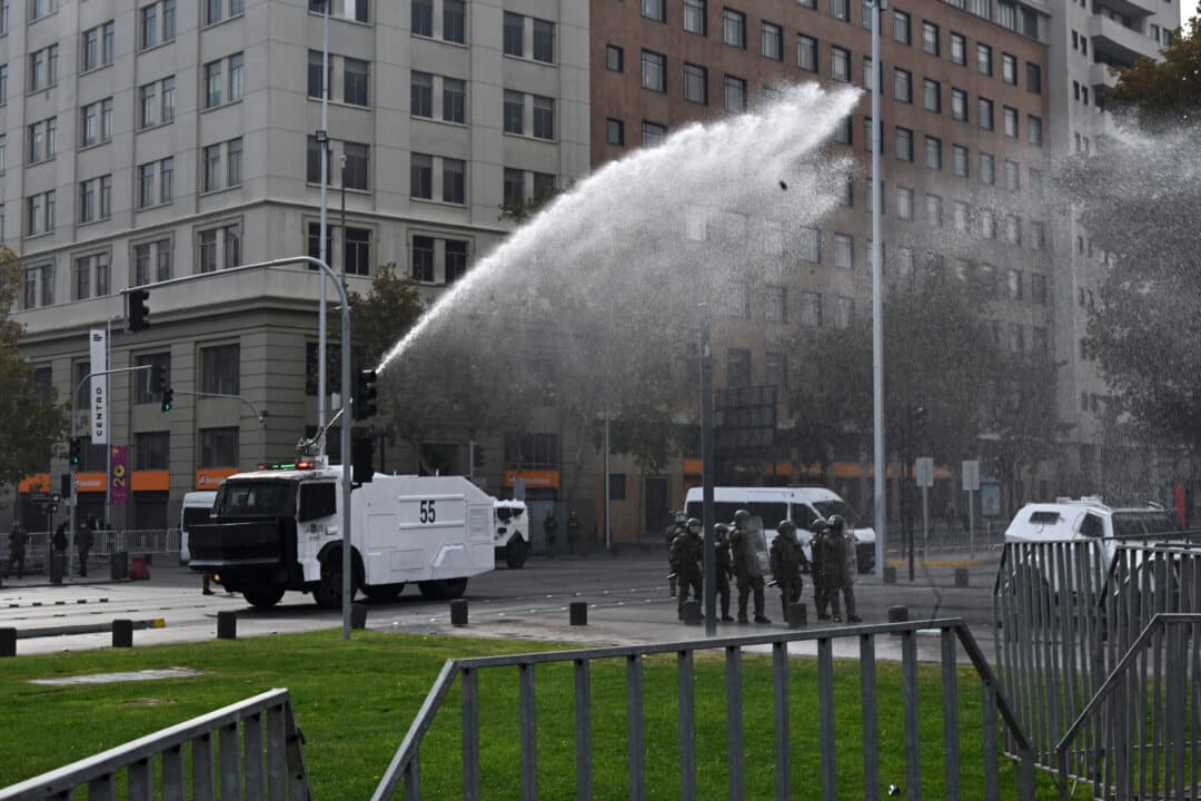 Riot police use a water cannon as high school and university students demonstrate against the government of President Jose Antonio Kast in Santiago, Chile, on May 14, 2026. (Rodrigo Arangua / AFP via Getty Images)