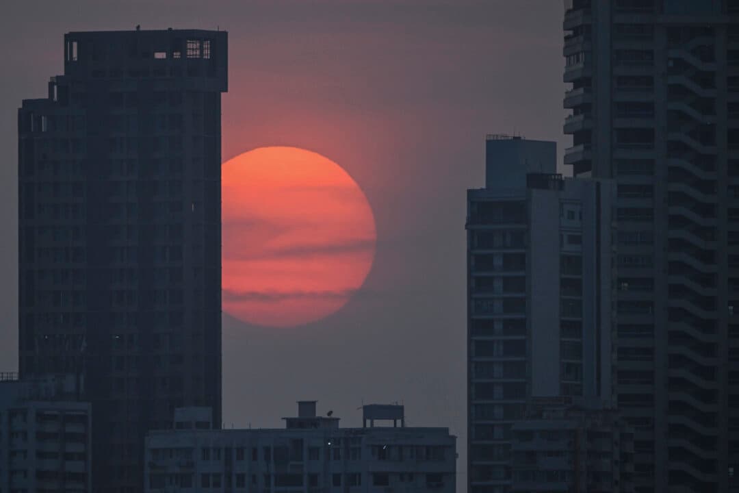 The sun sets against high-rise residential buildings in Mumbai, India, on May 14, 2026. (Punit Paranjpe/AFP via Getty Images)
