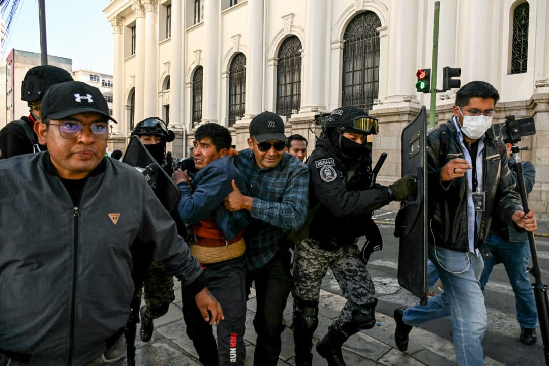 Police detain a miner after clashes erupted during a march to demand the resignation of President Rodrigo Paz in La Paz, Bolivia, on May 14, 2026. For the past two weeks, workers, farmers, school teachers, indigenous groups, and transport workers have been pressuring the government for higher wages and a halt to the privatization of public companies. (Aizar Radles/AFP via Getty Images)
