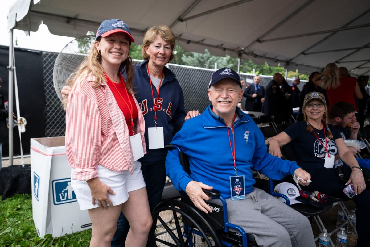 Michael Meagher (R), from Staten Island, New York, and a former captain of Engine 255, part of the New York City Fire Department on 9/11, watches the Memorial Day parade with his wife, Mary, and daughter, Grace, in Washington on May 25, 2026. (Madalina Kilroy/The Epoch Times)