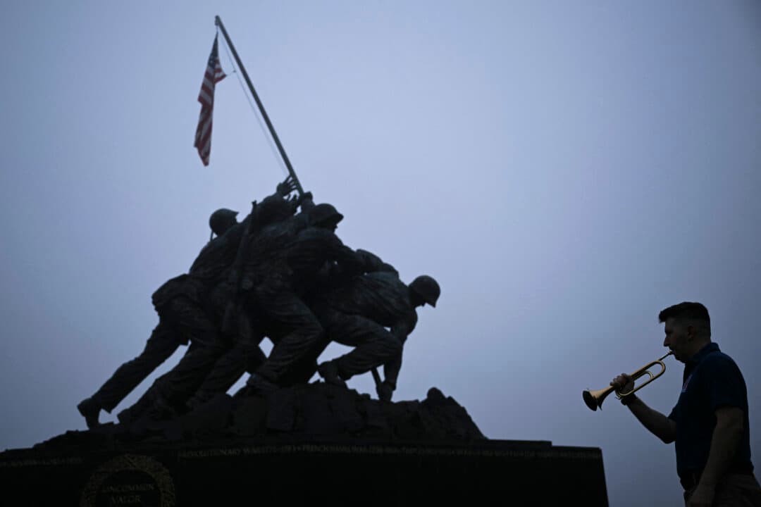 Ryan Brewer, military bandsman and member of the Doughboy Foundation, plays Taps at the Marine Corps War Memorial to mark Memorial Day in Arlington, Va., on May 25, 2026. (Brendan Smialowski/AFP via Getty Images)