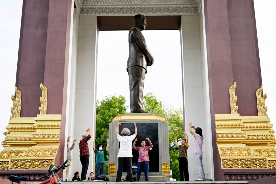 People perform Falun Dafa exercises next to a statue of the monument of the late king Norodom Sihanouk in Phnom Penh, Cambodia, on June 1, 2026. (Tang Chhin Sothy/AFP via Getty Images)