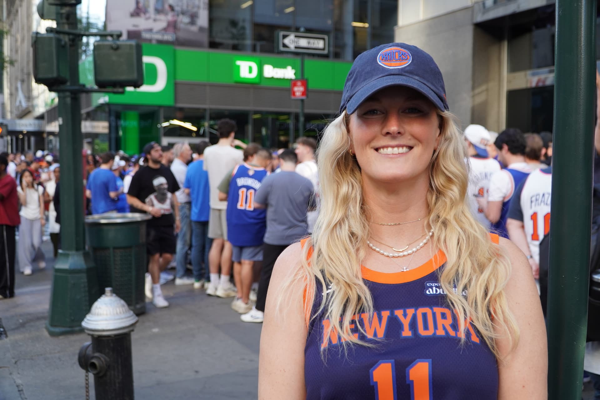 Sam Seath, a season ticket holder, said she goes to all the games with her father. Behind her is the line to get into the security perimeter around Madison Square Garden for Game 3 in New York on June 8, 2026. (Nicholas Zifcak/The Epoch Times)