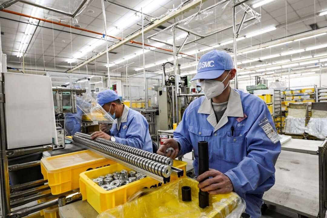 Workers on the production line of SMC, a pneumatic component manufacturer, during a media tour in Beijing on Jan. 10, 2023. Beijing's 2020 Export Control Law gave the Chinese regime its first unified framework for restricting strategic exports. (Jade Gao / AFP via Getty Images)