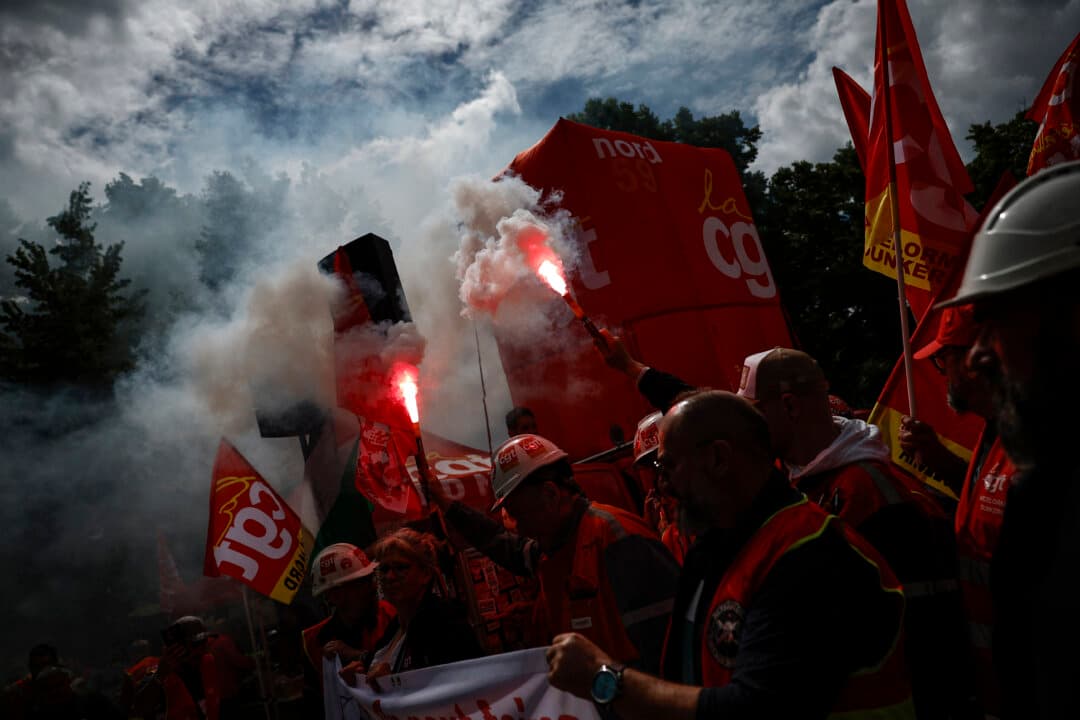 ArcelorMittal workers hold flares outside National Assembly, France's lower house of parliament, during a demonstration in support of the nationalization of the steelmaking giant, called by the General Confederation of Labor (CGT), as the bill comes before the National Assembly in Paris, on June 11, 2026. (Simon Wohlfahrt/AFP via Getty Images)