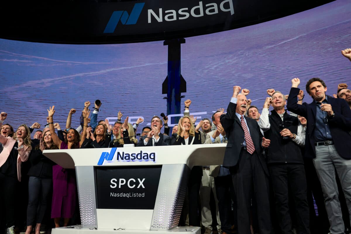 Gwynne Shotwell (at podium, center R), SpaceX president and chief operating officer, is joined by SpaceX executives and employees as they ring the opening bell at the Nasdaq MarketSite to celebrate the launch of SpaceX's initial public offering in New York City on June 12, 2026. (Timothy A. Clary / AFP via Getty Images)