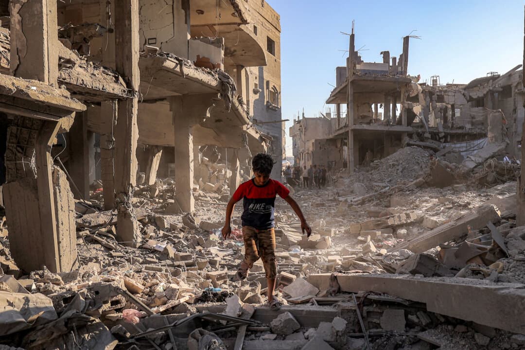 A boy walks through the rubble of a building destroyed in Israeli bombardment following an evacuation order at the Maghazi refugee camp in the central Gaza Strip on June 12, 2026. Violence has continued despite a ceasefire that has been in place since October 2025, with both Israel and Hamas accusing each other of violating the truce. (Eyad Baba/AFP via Getty Images)