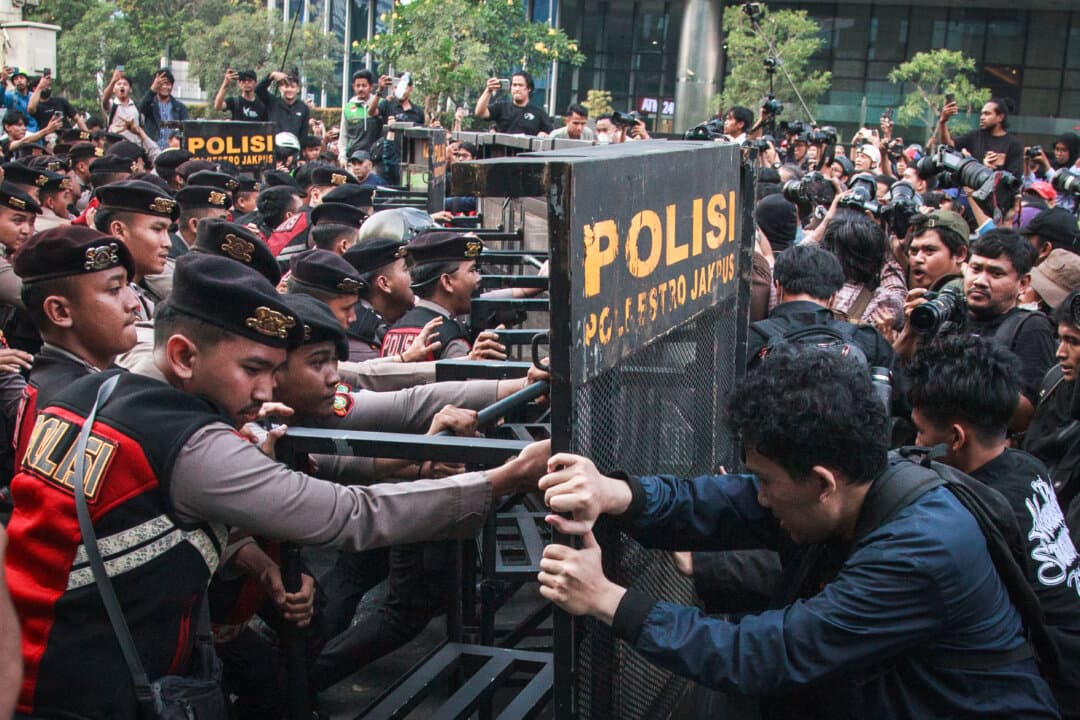 Police officers push back a barricade as university students protest against rising non-subsidized fuel prices, government spending, and the free school meals program in Jakarta, Indonesia, on June 12, 2026. Hundreds of students demonstrated to demand policy changes amid worsening economic conditions. (Aditya Irawan/AFP via Getty Images)