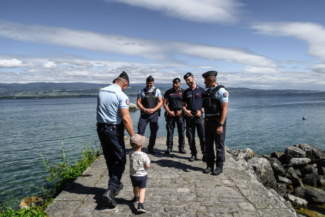 A child walks toward members of the French Gendarmerie and Italian Carabinieri to be photographed with them during a Franco-Italian Operational Unit (UOFI) deployment, in Yvoire, France, ahead of the G7 summit in Évian on June 12, 2026. (Jeff Pachoud/AFP via Getty Images)