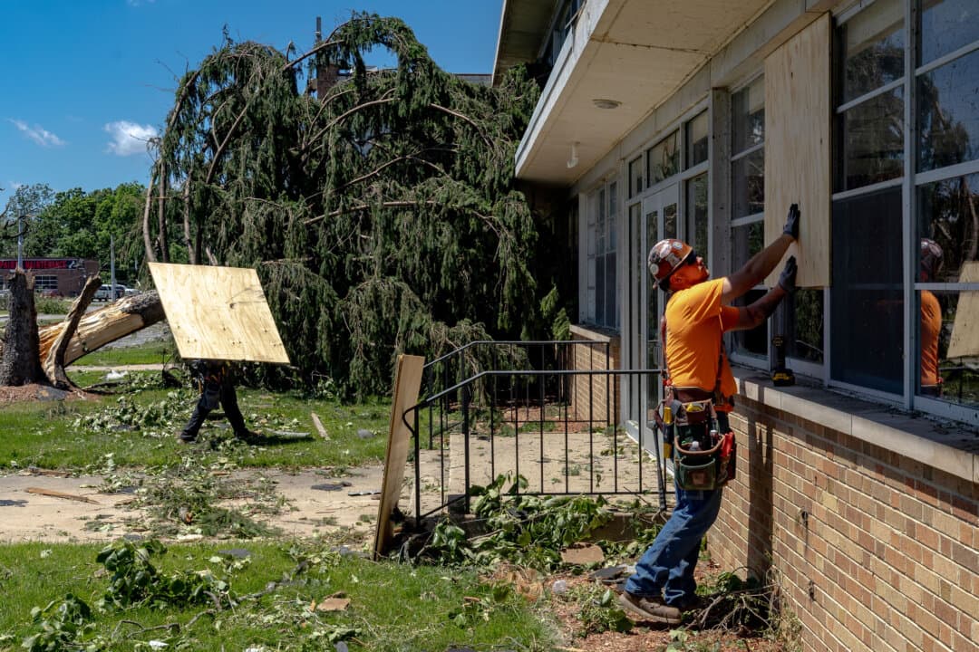 Clean up crews board up broken windows at Andrean High School after it was damaged by tornado winds in Merrillville, Ind., on June 12, 2026. A tornado system passed through the area the previous night, causing widespread damage to homes and businesses. (Jim Vondruska/Getty Images)