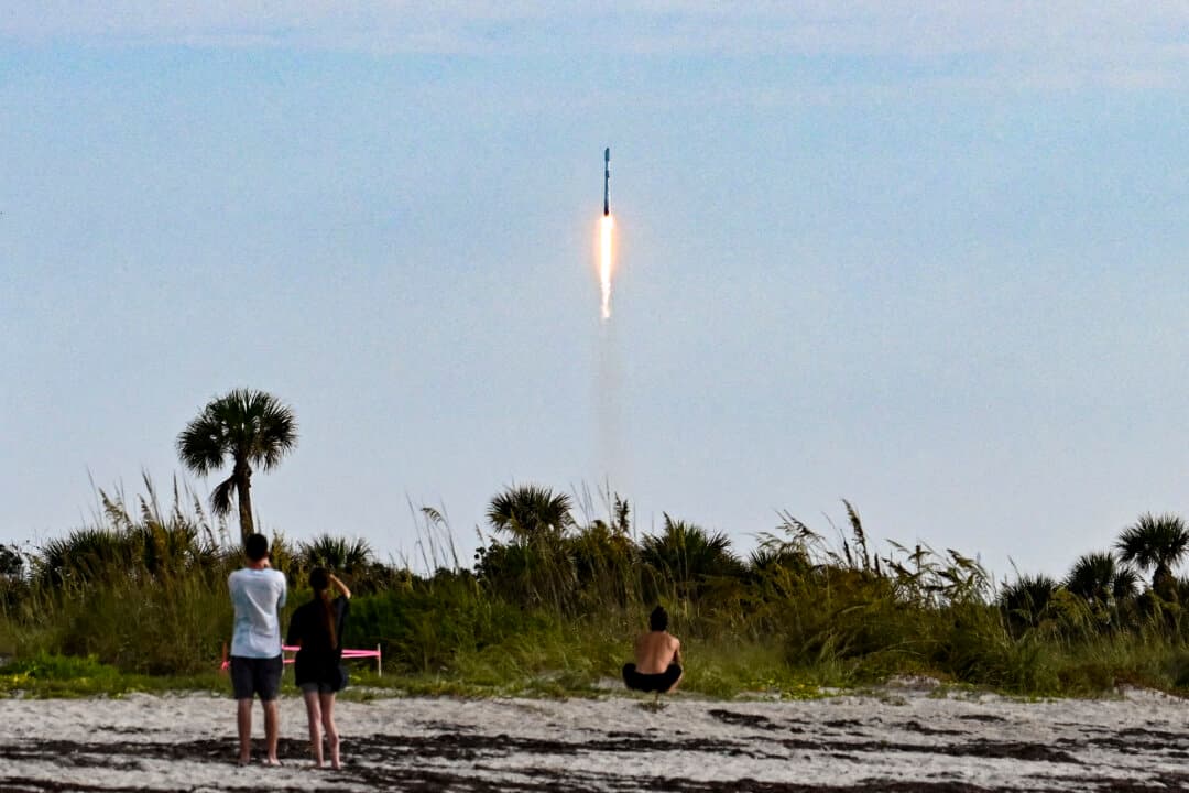 People watch as a SpaceX Falcon 9 rocket carrying the Starlink 10-54 mission lifts off from Space Launch Complex 40 at Cape Canaveral Space Force Station in Cape Canaveral, Fla., on June 12, 2026. Elon Musk's SpaceX began trading on the Nasdaq exchange on June 12 with the biggest initial public offering in history. (Chandan Khanna / AFP via Getty Images)