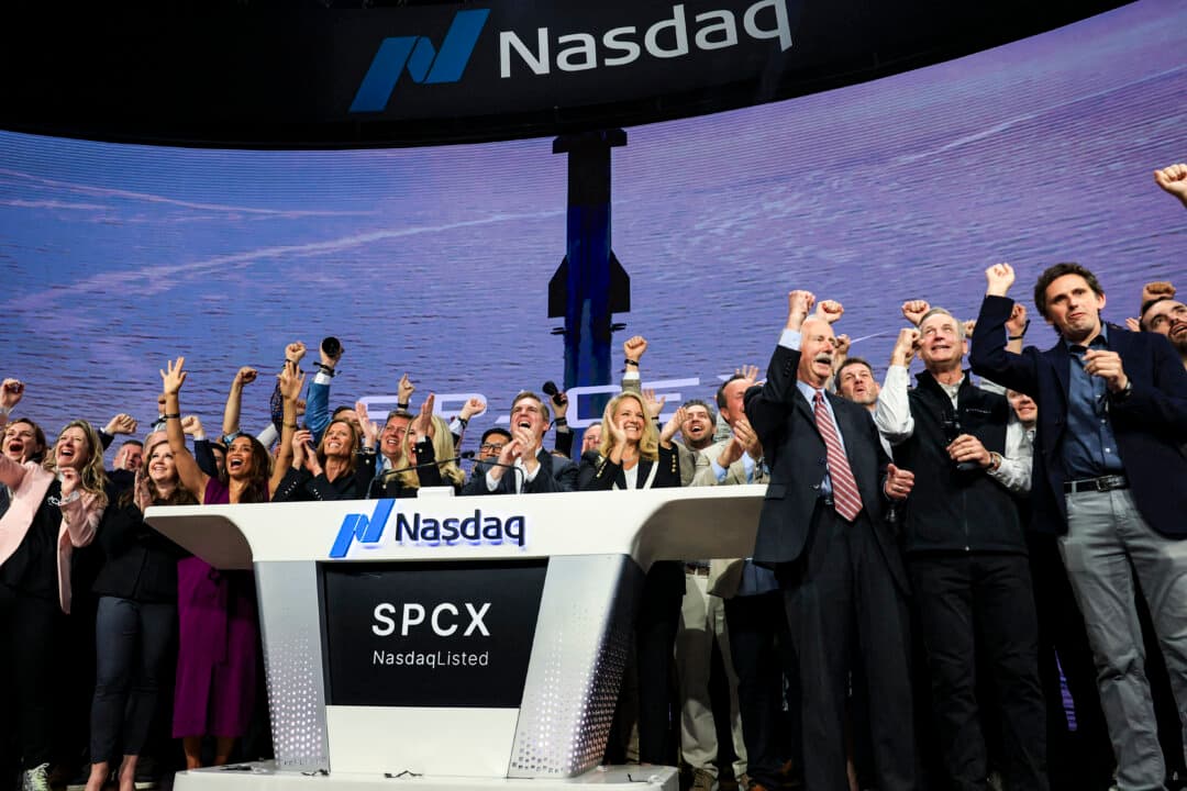 Gwynne Shotwell (at podium, center R), SpaceX president and chief operating officer, is joined by SpaceX executives and employees as they ring the opening bell at the Nasdaq MarketSite to celebrate the launch of SpaceX's initial public offering (IPO) in New York on June 12, 2026. Elon Musk's SpaceX began trading on the Nasdaq exchange on Friday with the biggest initial public offering in history making Musk the world's first trillionaire. (Timothy A. Clary / AFP via Getty Images)