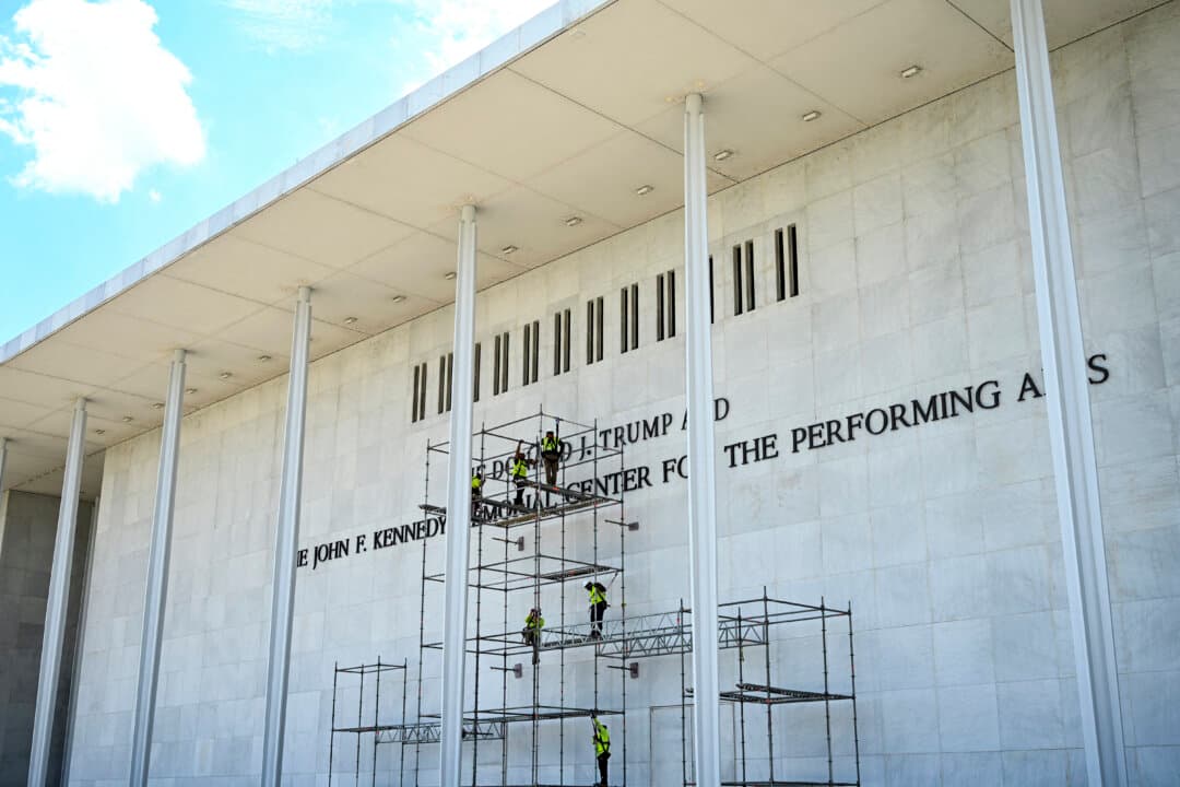 Workers stand on scaffolding near the signage for the Donald J. Trump and John F. Kennedy Memorial Center for the Performing Arts in Washington on June 12, 2026. A U.S. federal judge rejected a bid by the board of the Kennedy Center and the Justice Department to halt the removal of President Donald Trump's name from the performing arts venue. (Alex Wroblewski / AFP via Getty Images)