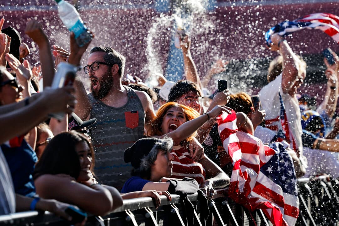 U.S. fans cheer after the United States scored its first goal in their World Cup match against Paraguay while watching the match at the FIFA Fan Festival at LA Memorial Coliseum in Los Angeles, on June 12, 2026. The United States defeated Paraguay 4–1 as Los Angeles began hosting eight matches during the global tournament. (Mario Tama/Getty Images)