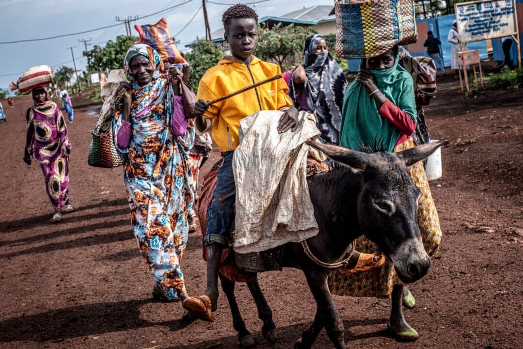 A Sudanese refugee boy rides a donkey along the main road of the Ura Refugee Site with members of his family in Asosa Zone, Benishangul-Gumuz region, Ethiopia, on June 19, 2026. (Marco Simoncelli/AFP via Getty Images)