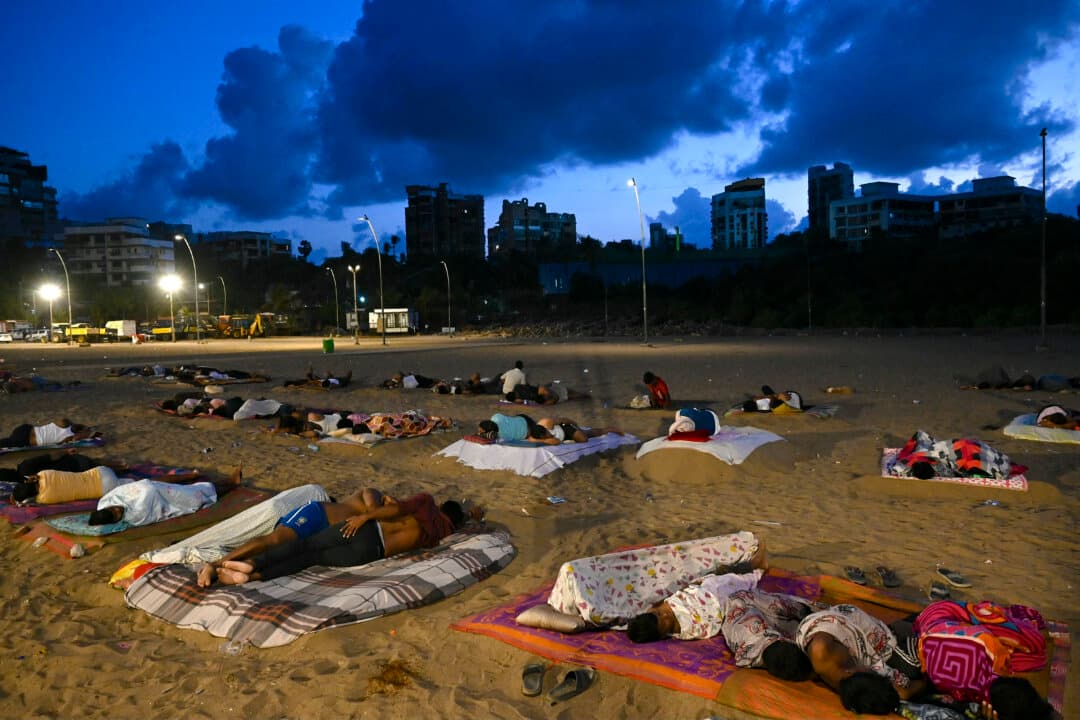 Residents from nearby slum settlements sleep on Versova Beach to escape the hot and humid conditions inside their homes, during the early-morning hours in Mumbai, India, on June 19, 2026. (Indranil Mukherjee/AFP via Getty Images)