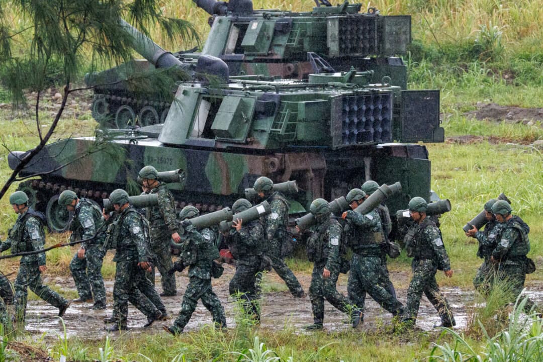Taiwanese soldiers carry artillery shells for an M109A2 self-propelled howitzer during a live-fire training exercise in Taichung on June 9, 2026. By 2030, Taiwan's President Lai Ching-te wants to raise the country's military budget to 5 percent of GDP from around 3 percent.(Cheng Yu-chen / AFP via Getty Images)