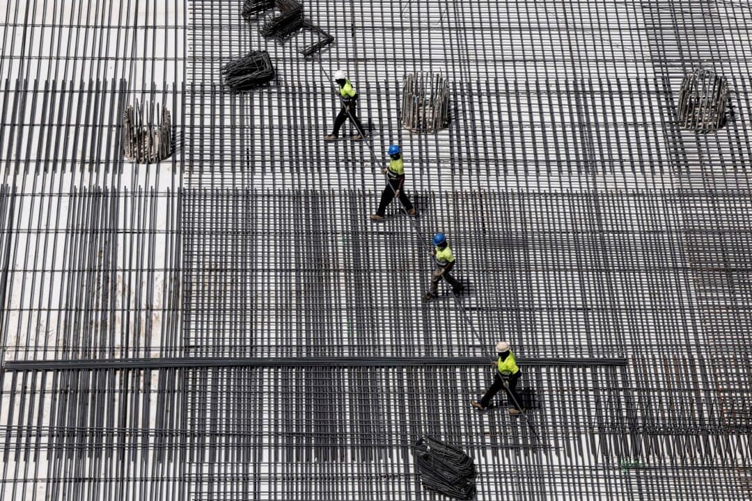 Workers install a metallic structure at a construction site for a bus terminal in Madrid, on June 22, 2026, during the heat wave affecting the Iberian Peninsula. Large parts of Spain are experiencing unusually high temperatures for June as a mass of hot air from North Africa moves across the Iberian Peninsula. (Oscar del Pozo/AFP via Getty Images)