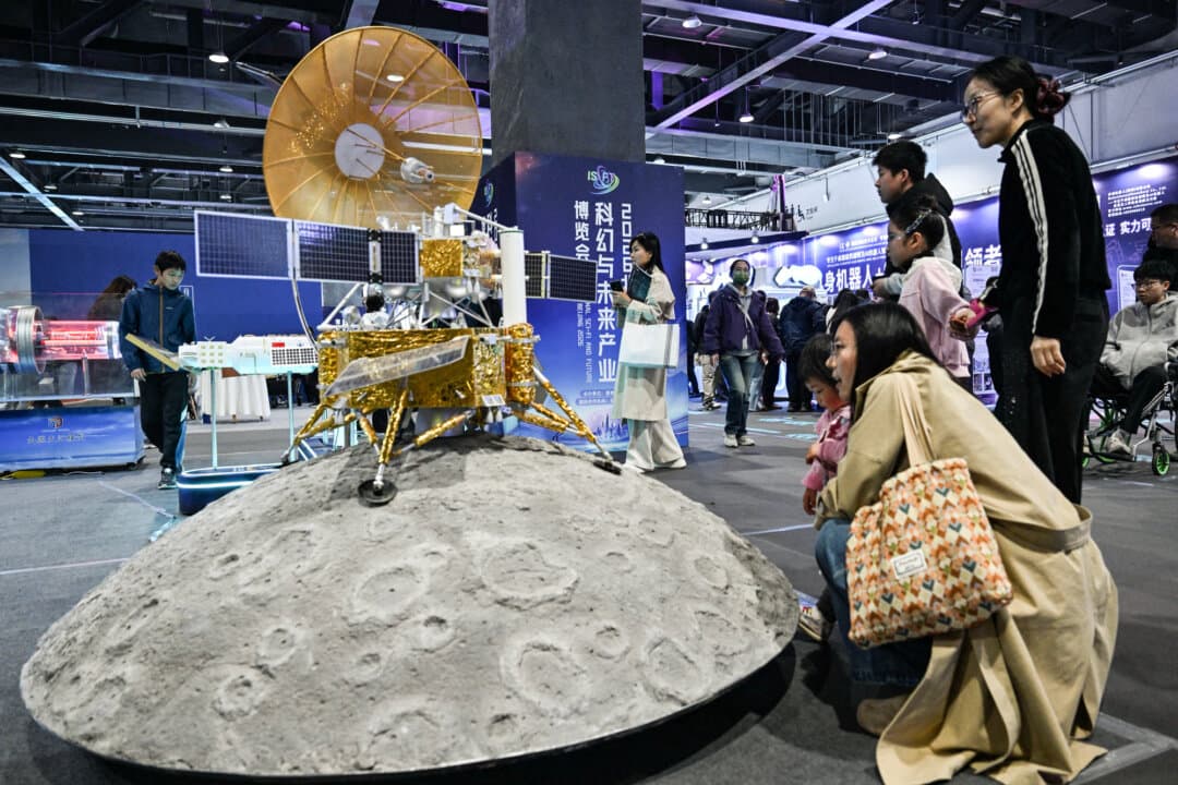 People vew a model from Chang'e 6, China's sixth robotic lunar exploration mission, during the Beijing Sci-Fi Carnival in Beijing on March 28, 2026. China relies on its space program to lift the public mood, a Taiwanese defense researcher told The Epoch Times. (Adek Berry / AFP via Getty Images)