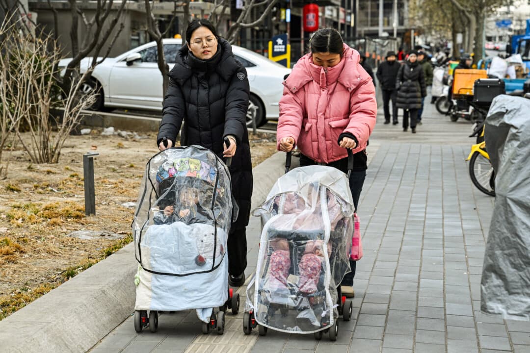 Women push baby strollers along a street in Beijing on Jan. 4, 2026. The number of births in China in 2025 hit a record low, while the proportion of adults aged 60 and over reached about 23 percent. (Adek Berry / AFP via Getty Images)