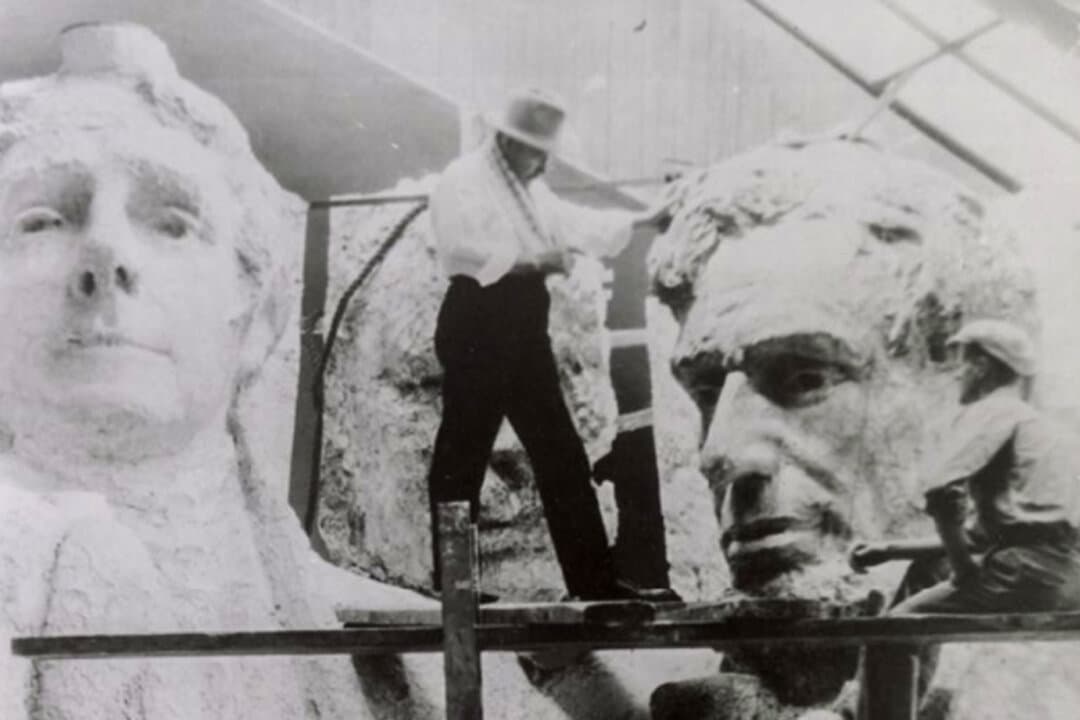 (Left) Compressors are stored during the construction of Mount Rushmore near Keystone, S.D., in this file photo. (Right) Sculptor Gutzon Borglum works on Mount Rushmore models near Keystone, S.D., in this file photo. Borglum crafted scale models of the presidents’ heads, then devised a way to transfer their proportions to the mountain. (Courtesy of South Dakota Historical Society)