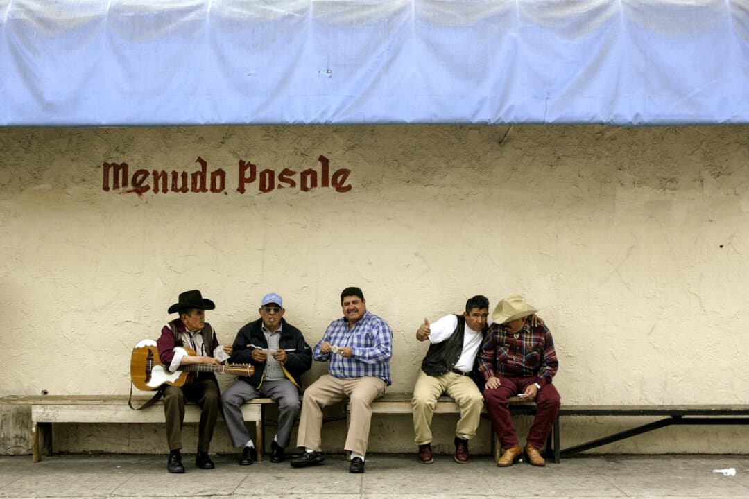 Men sit on a bench outside a Mexican restaurant in Los Angeles on April 27, 2005. The Mexican-born population in the United States grew from fewer than 800,000 in 1970 to nearly 12 million in 2010. (Hector Mata/AFP via Getty Images)