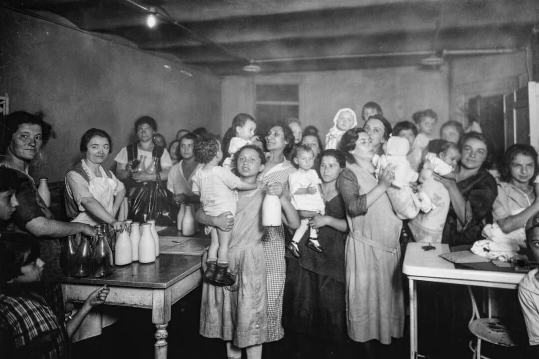 Mothers and their babies gather at a health station for feeding babies with bottled milk, on Madison Street, New York City, circa 1930. Infant mortality—which claimed about 100 babies per 1,000 births in 1915, fell throughout the 20th century to 5.4 infant deaths per 1,000 births in 2025, due to advances in medicine and other factors. (Keystone View Company/FPG/Archive Photos/Getty Images)