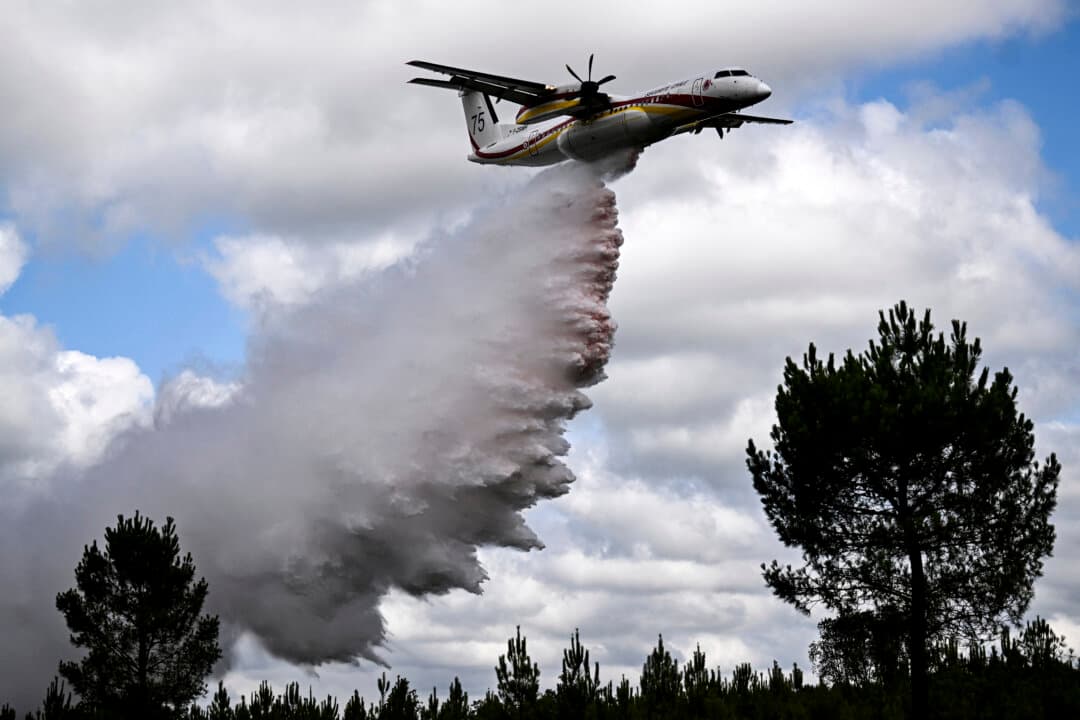 A Dash Q400-MR Fireguard aircraft of the civil security drops retardant mixed with water during a demonstration of firefighting capacity by the Gironde's Fire and Rescue Departmental Service in Saint-Aubin-de-Médoc, France, on July 3, 2026. Hundreds of firefighters are battling wildfires in southern France that are being fueled by wind, drought, and heat. (Christophe Archambault/AFP via Getty Images)