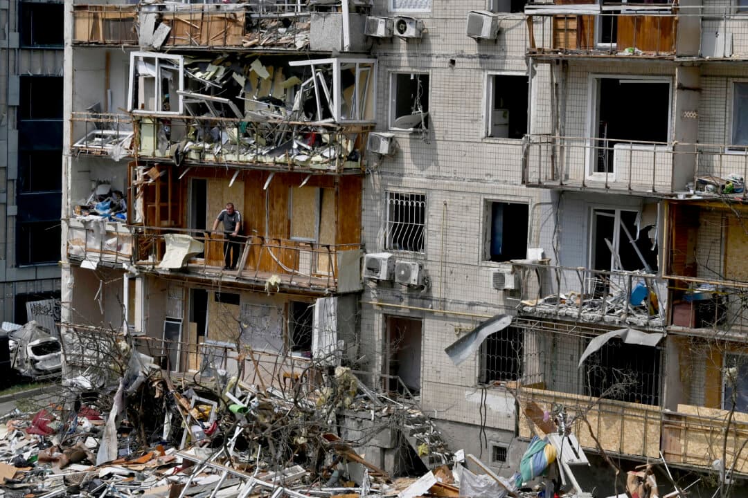 A local resident stands on the balcony of his flat in a residential building damaged by a Russian air attack on the Ukrainian capital of Kyiv, on July 3, 2026. Russia launched its largest ever barrage on Kyiv early July 2, 2026, according to the city's mayor. (Sergei Supinsky/AFP via Getty Images)